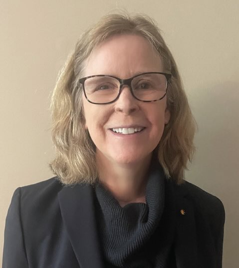 A photo of a smiling woman with glasses.